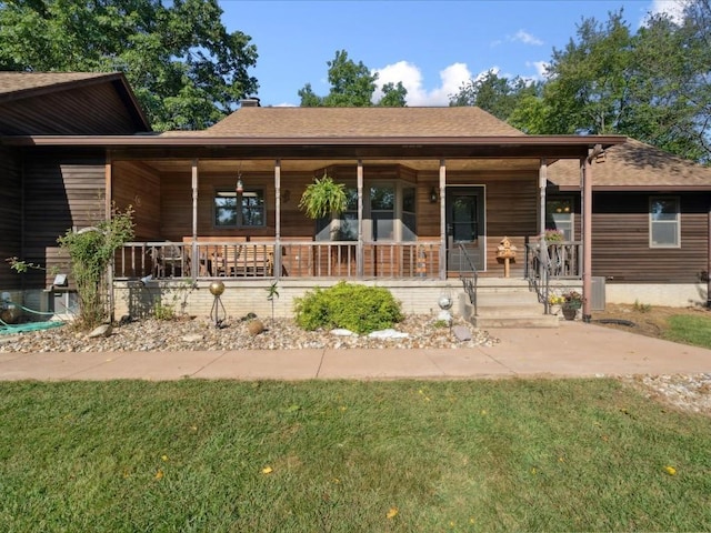 1901 42nd St SE, Cedar Rapids, IA 52403 - view of front of house featuring a porch, roof with shingles, a front yard, and a chimney