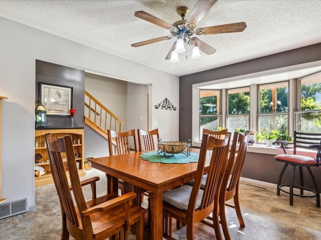 1901 42nd St SE, Cedar Rapids, IA 52403 - dining area with ceiling fan, stairway, a textured ceiling, and a dry bar
