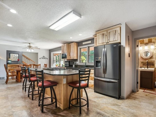 1901 42nd St SE, Cedar Rapids, IA 52403 - kitchen with appliances with stainless steel finishes, a center island, dark countertops, a breakfast bar, and a textured ceiling