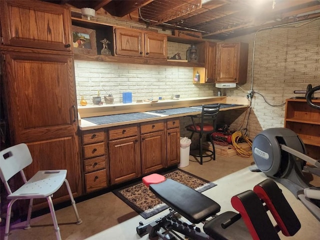 1901 42nd St SE, Cedar Rapids, IA 52403 - kitchen featuring brick wall, open shelves, finished concrete floors, brown cabinetry, and light countertops