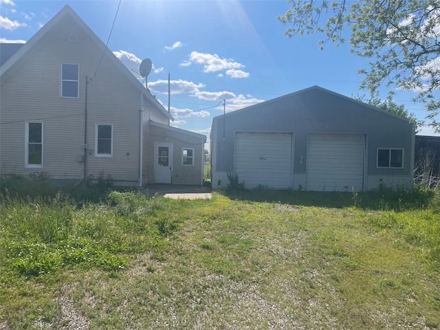 2902 Water St, Columbus City, IA 52737 - rear view of property featuring a detached garage, an outdoor structure, and a lawn