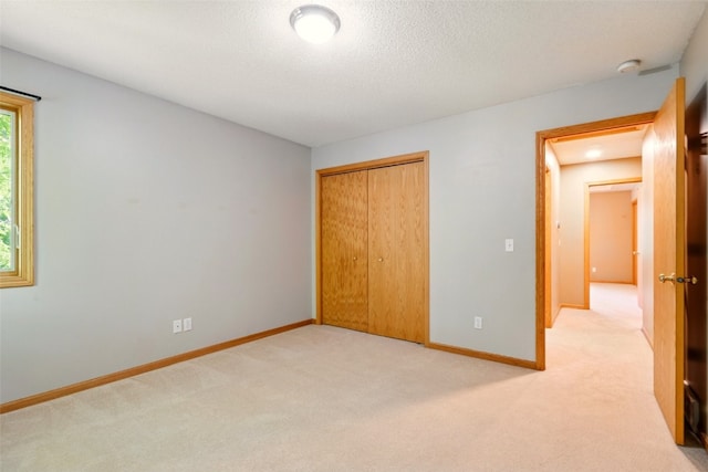 6967 Doubletree Rd NE, Cedar Rapids, IA 52402 - unfurnished bedroom with light carpet, a closet, baseboards, and a textured ceiling