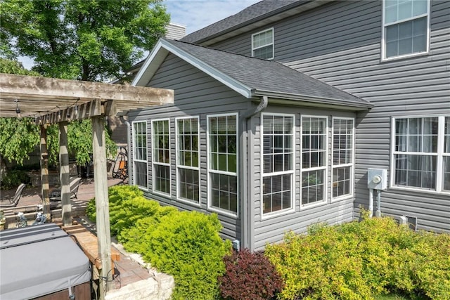 6919 Rockingham Dr SW, Cedar Rapids, IA 52404 - view of side of property featuring a pergola, a shingled roof, a patio area, and a hot tub