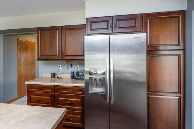 6919 Rockingham Dr SW, Cedar Rapids, IA 52404 - kitchen featuring stainless steel fridge, light countertops, light tile patterned floors, and a textured ceiling