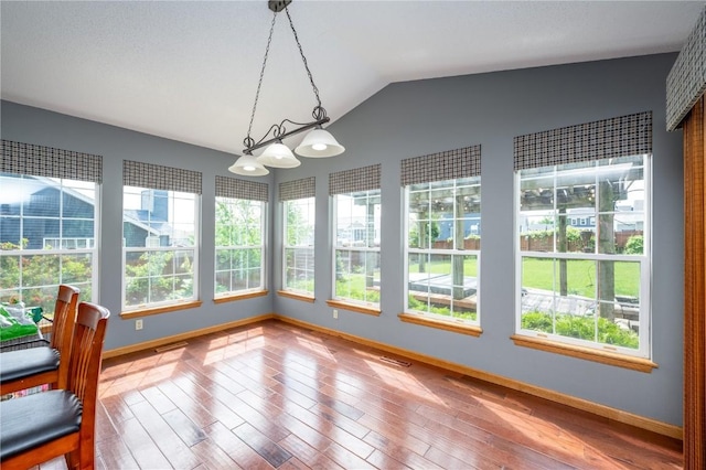 6919 Rockingham Dr SW, Cedar Rapids, IA 52404 - unfurnished sunroom with lofted ceiling, wood finished floors, and baseboards