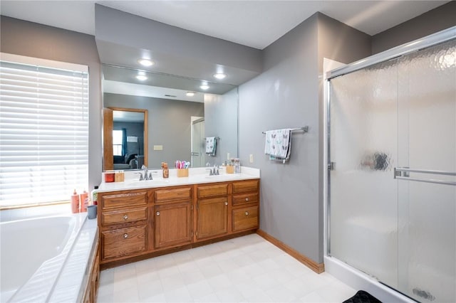 6919 Rockingham Dr SW, Cedar Rapids, IA 52404 - full bath featuring a shower stall, double vanity, a garden tub, and baseboards