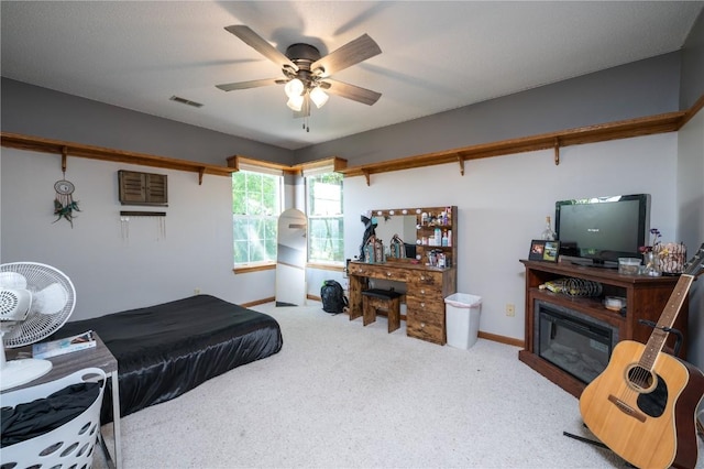 6919 Rockingham Dr SW, Cedar Rapids, IA 52404 - carpeted bedroom featuring a glass covered fireplace, baseboards, and a ceiling fan