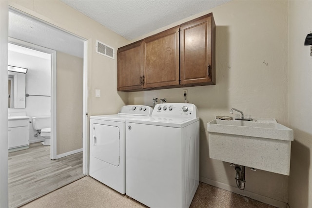 5712 Golden Ct NE Unit 60, Cedar Rapids, IA 52402 - laundry room with cabinet space, independent washer and dryer, baseboards, and a textured ceiling