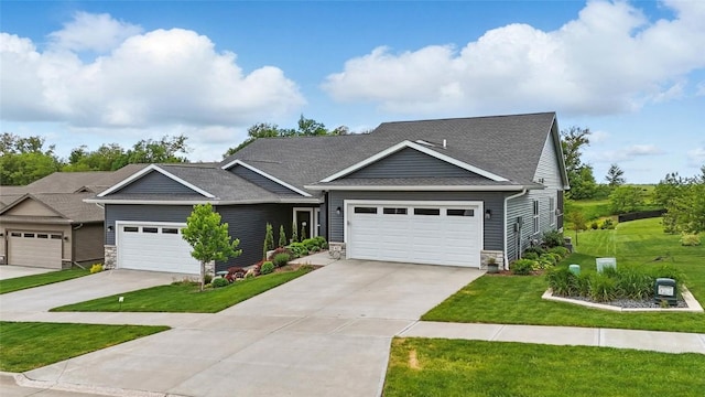 927 Summit Ct, Tiffin, IA 52340 - view of front of property with stone siding, a front lawn, driveway, and roof with shingles