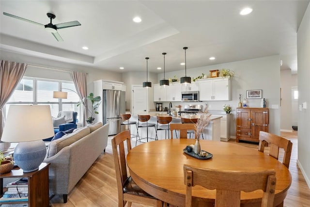 927 Summit Ct, Tiffin, IA 52340 - dining space featuring recessed lighting, light wood finished floors, a ceiling fan, baseboards, and a tray ceiling