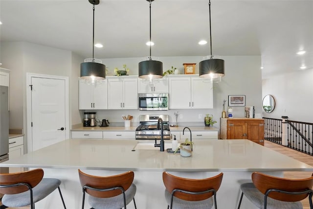 927 Summit Ct, Tiffin, IA 52340 - kitchen featuring stainless steel appliances, recessed lighting, light countertops, white cabinetry, and an island with sink
