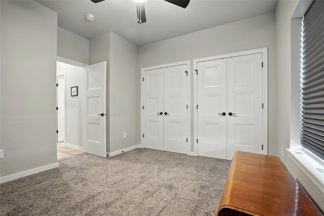 927 Summit Ct, Tiffin, IA 52340 - unfurnished bedroom with light carpet, two closets, baseboards, and ceiling fan