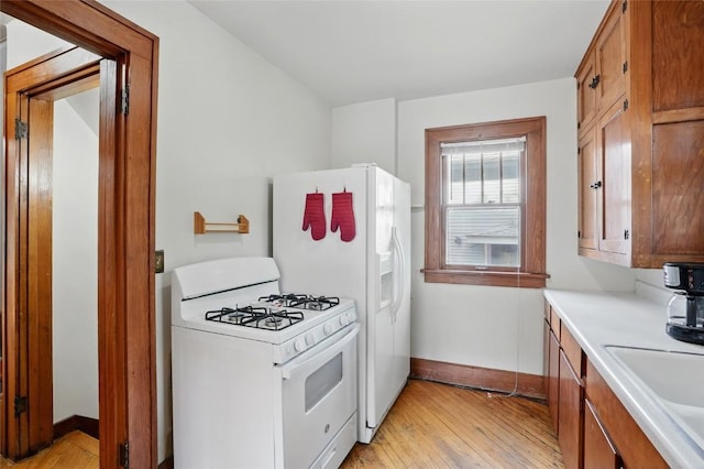715 E Market St, Iowa City, IA 52245 - kitchen featuring white appliances, light wood-style flooring, baseboards, and light countertops