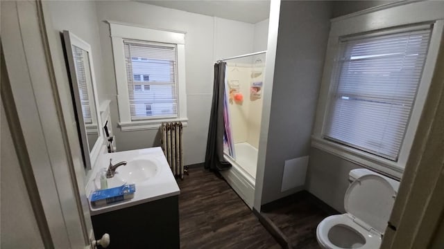 728 4th Ave SE, Cedar Rapids, IA 52401 - full bath featuring toilet, vanity, radiator, wood finished floors, and shower / bath combination with curtain