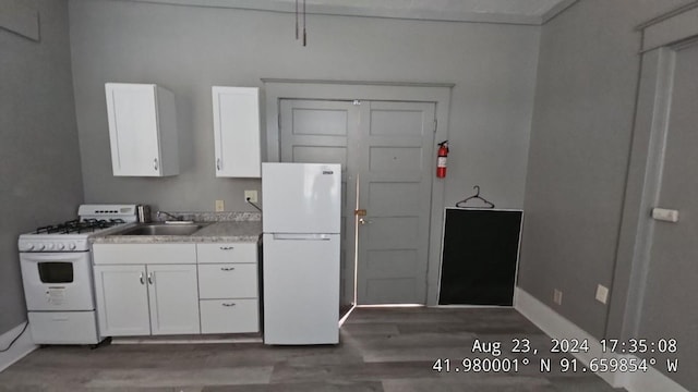 728 4th Ave SE, Cedar Rapids, IA 52401 - kitchen with white appliances, wood finished floors, white cabinetry, and a sink
