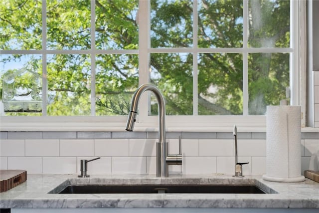5150 Prairie Ridge Dr, Marion, IA 52302 - detailed view of a sink, light stone counters, and decorative backsplash