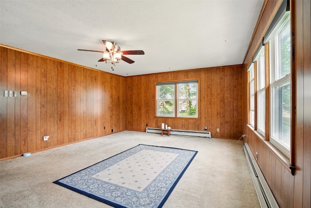 113 Chaffee Dr, Hiawatha, IA 52233 - empty room featuring a baseboard radiator, ceiling fan, wood walls, and carpet flooring