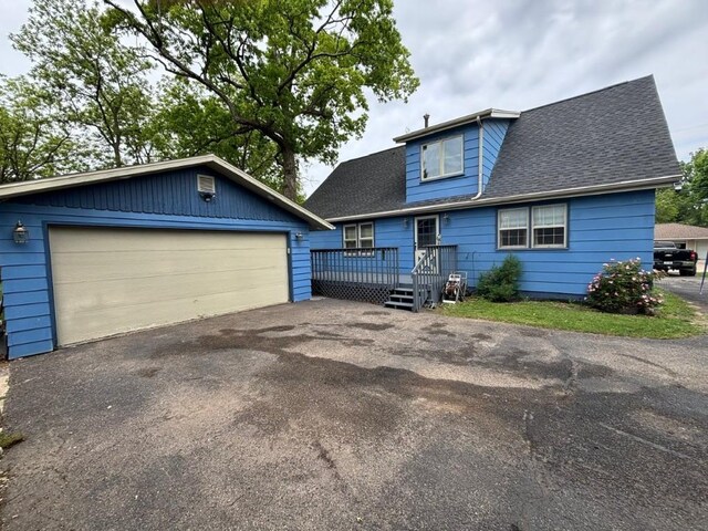 113 Chaffee Dr, Hiawatha, IA 52233 - view of front facade featuring an outdoor structure, a deck, a garage, and a shingled roof