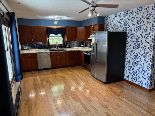 113 Chaffee Dr, Hiawatha, IA 52233 - kitchen with stainless steel appliances, a sink, light wood finished floors, wallpapered walls, and light countertops