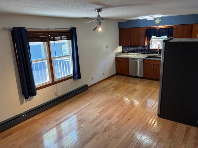 113 Chaffee Dr, Hiawatha, IA 52233 - kitchen featuring stainless steel appliances, a baseboard heating unit, light wood-style flooring, a sink, and a textured ceiling