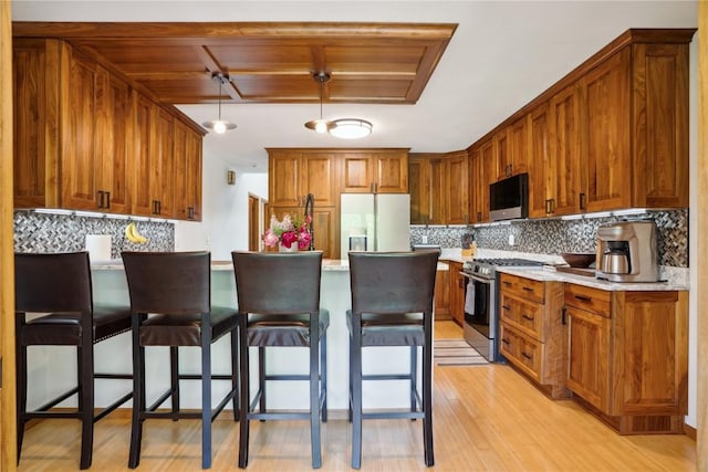 2545 F52 Trl, Parnell, IA 52325 - kitchen with appliances with stainless steel finishes, a peninsula, backsplash, and a breakfast bar