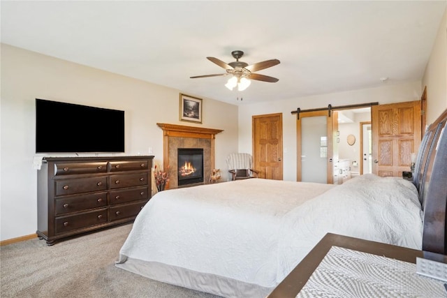 2545 F52 Trl, Parnell, IA 52325 - bedroom with light colored carpet, a fireplace, a ceiling fan, a barn door, and baseboards