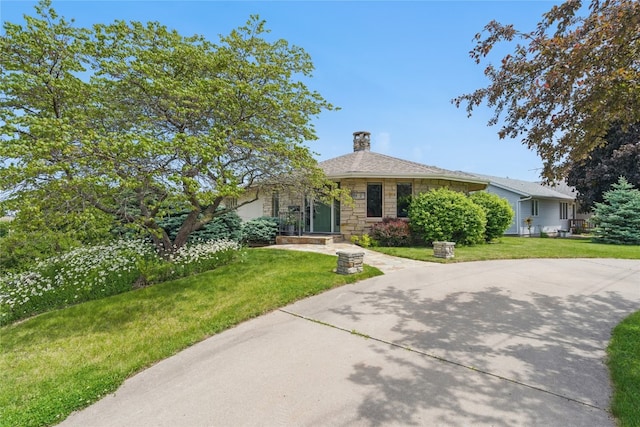 1004 W Welsh St, Williamsburg, IA 52361 - view of front facade featuring stone siding, a front lawn, and a chimney