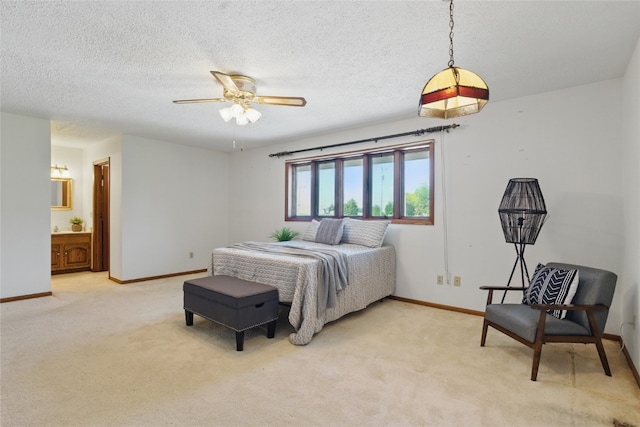 1004 W Welsh St, Williamsburg, IA 52361 - bedroom featuring light colored carpet, baseboards, ensuite bath, a textured ceiling, and a ceiling fan