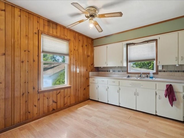 245 5th Ave, Marion, IA 52302 - kitchen featuring a sink, decorative backsplash, light countertops, light wood-style floors, and wood walls