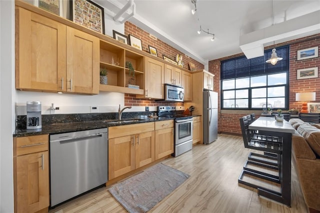 905 3rd St SE Unit 508, Cedar Rapids, IA 52401 - kitchen featuring appliances with stainless steel finishes, a sink, brick wall, light brown cabinets, and open shelves