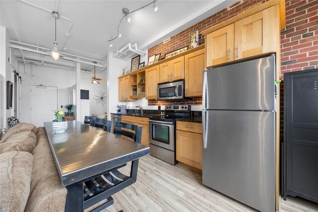 905 3rd St SE Unit 508, Cedar Rapids, IA 52401 - kitchen with stainless steel appliances, a sink, open shelves, light wood-style flooring, and open floor plan