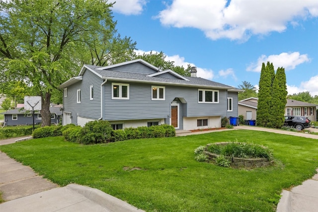 2536 N Ave NW, Cedar Rapids, IA 52405 - bi-level home with a front yard, a chimney, a garage, and roof with shingles