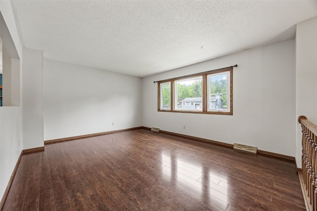 2536 N Ave NW, Cedar Rapids, IA 52405 - empty room featuring wood finished floors, a textured ceiling, and baseboards