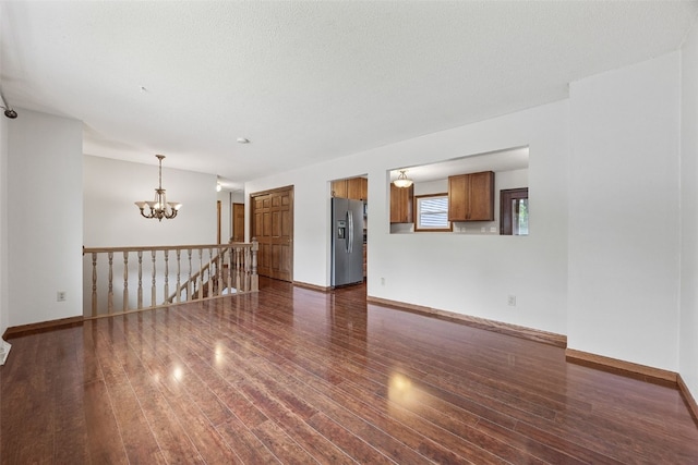 2536 N Ave NW, Cedar Rapids, IA 52405 - spare room featuring a chandelier, dark wood-type flooring, and baseboards