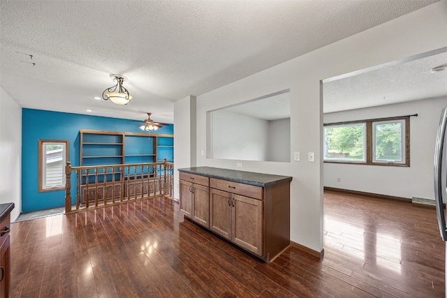2536 N Ave NW, Cedar Rapids, IA 52405 - kitchen featuring a textured ceiling, dark wood-style floors, ceiling fan, dark countertops, and baseboards