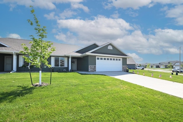 3902 Bluebird Dr SW, Cedar Rapids, IA 52404 - view of front of home with an attached garage, driveway, a front yard, and stone siding