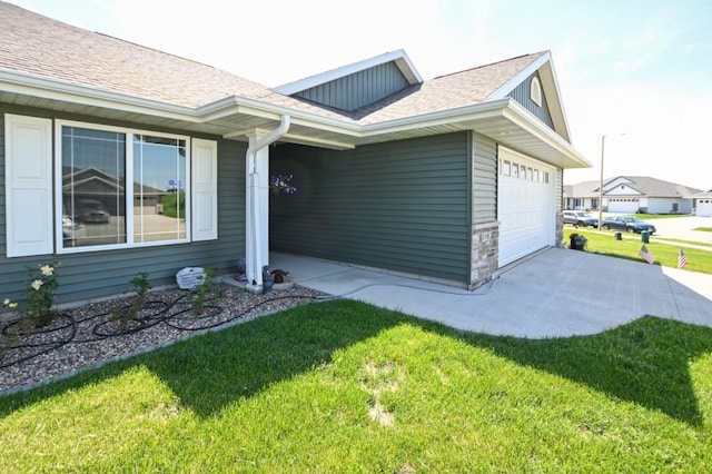 3902 Bluebird Dr SW, Cedar Rapids, IA 52404 - view of front of house with a front yard, a shingled roof, an attached garage, and concrete driveway