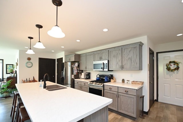 3902 Bluebird Dr SW, Cedar Rapids, IA 52404 - kitchen with stainless steel appliances, a sink, gray cabinetry, a center island with sink, and recessed lighting