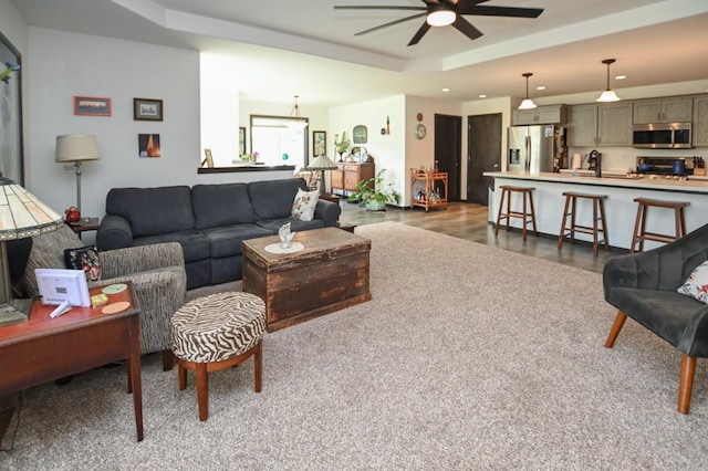 3902 Bluebird Dr SW, Cedar Rapids, IA 52404 - living area with a tray ceiling, a ceiling fan, recessed lighting, and dark wood-style floors