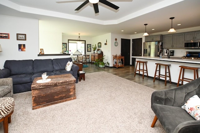 3902 Bluebird Dr SW, Cedar Rapids, IA 52404 - living area with ceiling fan, a tray ceiling, dark wood-type flooring, and recessed lighting
