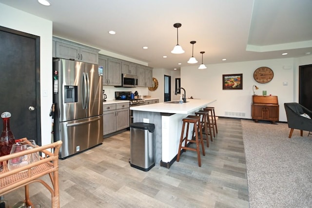 3902 Bluebird Dr SW, Cedar Rapids, IA 52404 - kitchen featuring stainless steel appliances, a sink, light wood-style floors, recessed lighting, and a breakfast bar area