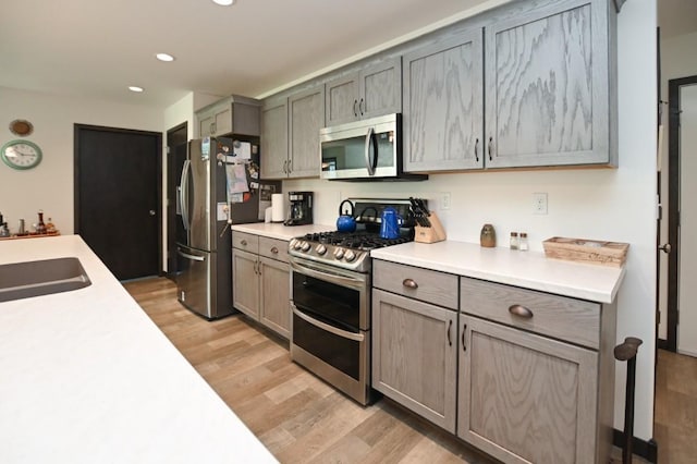 3902 Bluebird Dr SW, Cedar Rapids, IA 52404 - kitchen featuring appliances with stainless steel finishes, a sink, light wood finished floors, light countertops, and recessed lighting