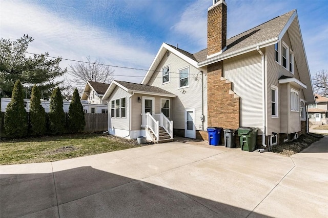 384 21st St SE, Cedar Rapids, IA 52403 - rear view of house featuring a chimney and a shingled roof