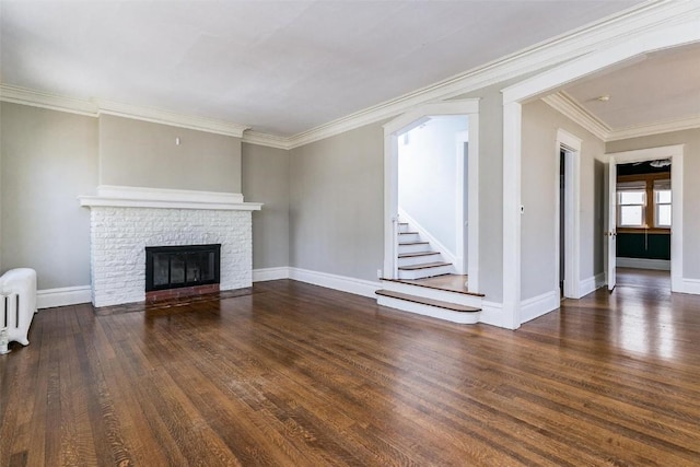 384 21st St SE, Cedar Rapids, IA 52403 - unfurnished living room featuring wood finished floors, radiator heating unit, ornamental molding, baseboards, and a fireplace