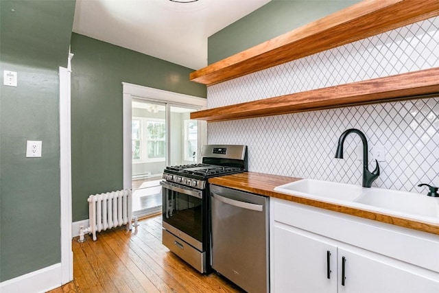 384 21st St SE, Cedar Rapids, IA 52403 - kitchen with open shelves, appliances with stainless steel finishes, radiator heating unit, and a sink