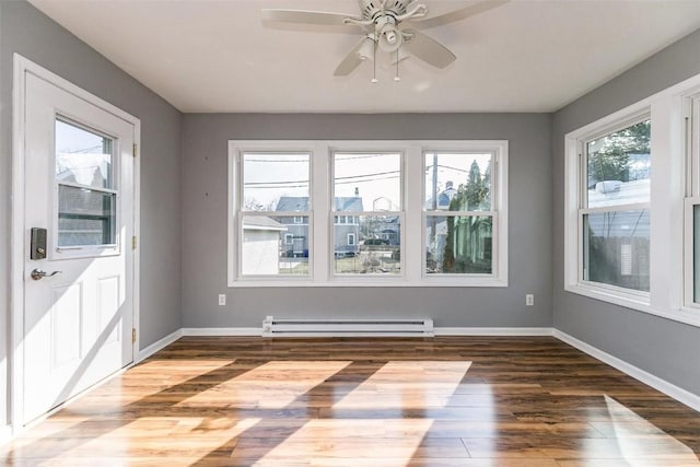 384 21st St SE, Cedar Rapids, IA 52403 - spare room featuring baseboard heating, wood finished floors, baseboards, and ceiling fan