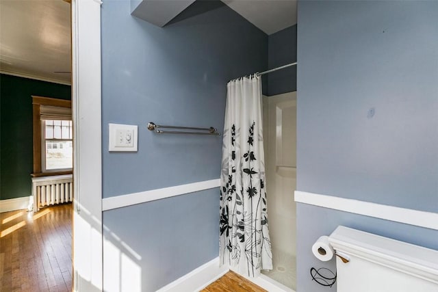 384 21st St SE, Cedar Rapids, IA 52403 - bathroom with radiator heating unit, hardwood / wood-style flooring, a shower with shower curtain, baseboards, and toilet