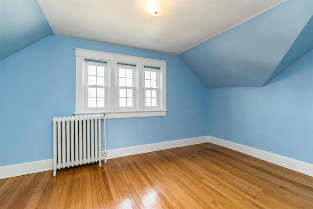 384 21st St SE, Cedar Rapids, IA 52403 - bonus room featuring radiator heating unit, lofted ceiling, light wood-type flooring, and baseboards