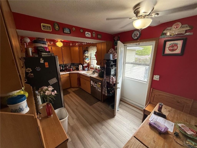 101 26th Avenue Dr SW, Cedar Rapids, IA 52404 - kitchen featuring freestanding refrigerator, light countertops, ceiling fan, a sink, and light wood-type flooring