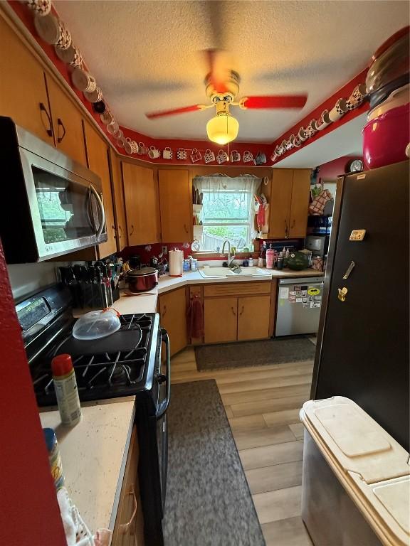 101 26th Avenue Dr SW, Cedar Rapids, IA 52404 - kitchen featuring stainless steel appliances, a sink, light countertops, a ceiling fan, and a textured ceiling